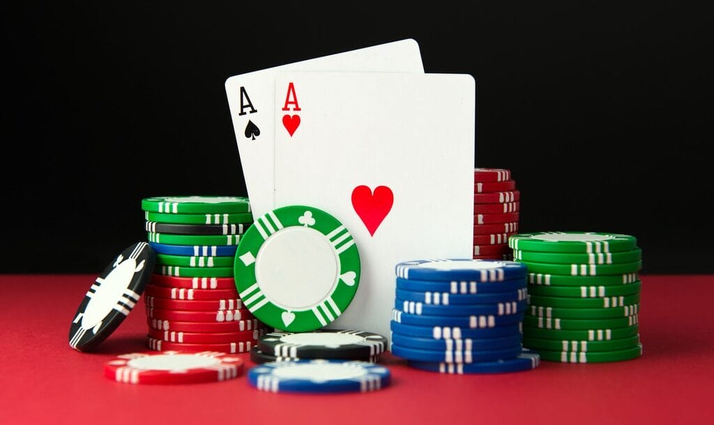 A pair of aces are propped up by stacks of poker chips.