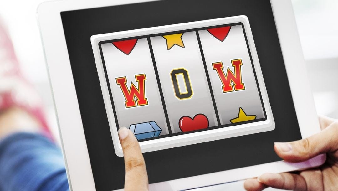 A person playing an online slot game on a white tablet.