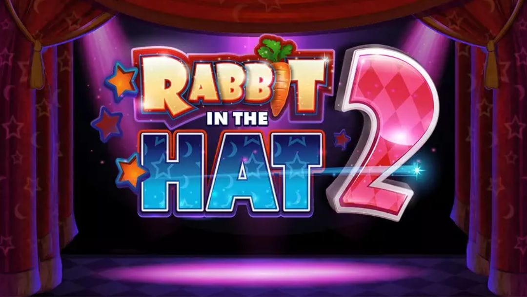 The Rabbit in the Hat 2 slot title screen. The background is a dark stage with three purple lights pointing towards its centre. Dark red stage curtains with a pattern featuring star and moon outlines are visible to the left, right, and top of the stage. In the foreground is the game title Rabbit in the Hat 2. The word Rabbit is visible in a slightly cartoon-style font with a carrot for the letter I. The word Hat has a blue gradient with outlines of stars and moons on it. The number 2 has a diamond pattern on it.