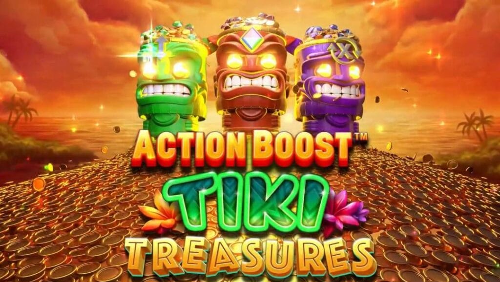 A screenshot of the Action Boost Tiki Adventures title from the promotional video. Three Tiki totems, one green, one red, and one purple, sit on a pile of gold in front of a beautiful golden island with the ocean in the background and stormy clouds above.