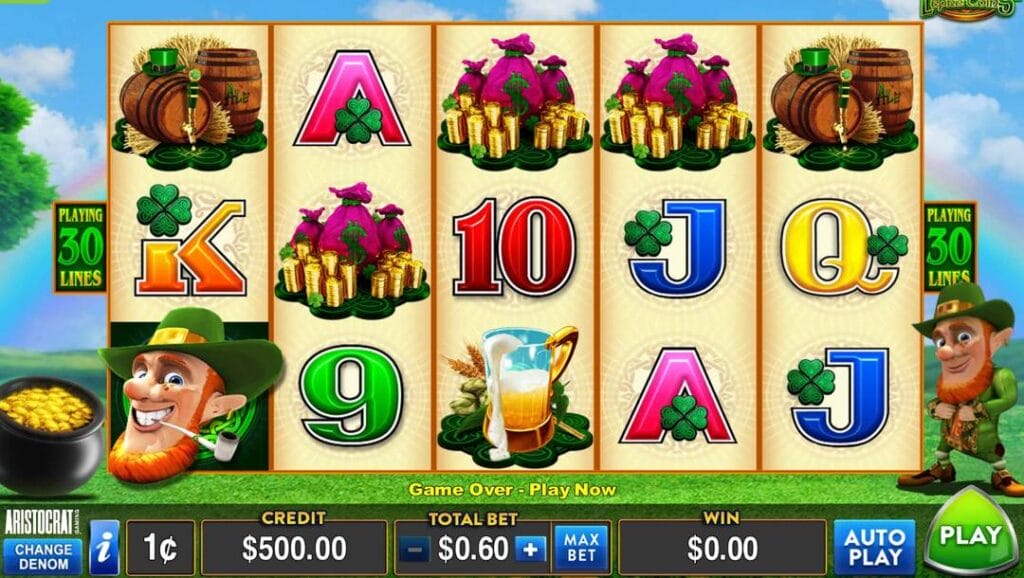 A screenshot of the reels in Wild Lepre’coins. The background is a picturesque blue sky with clouds and a rainbow above beautiful green hills. A pot of gold and a leprechaun appear on the left and right sides of the reels. The reels contain a mix of symbols, including high-value symbols, like the leprechaun’s face, barrels of ale, bags of gold, and standard symbols like the A, K, Q, and J.